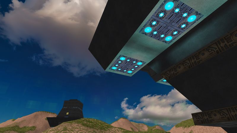 Monolithic structure overhead with cyan light panels against a blue sky